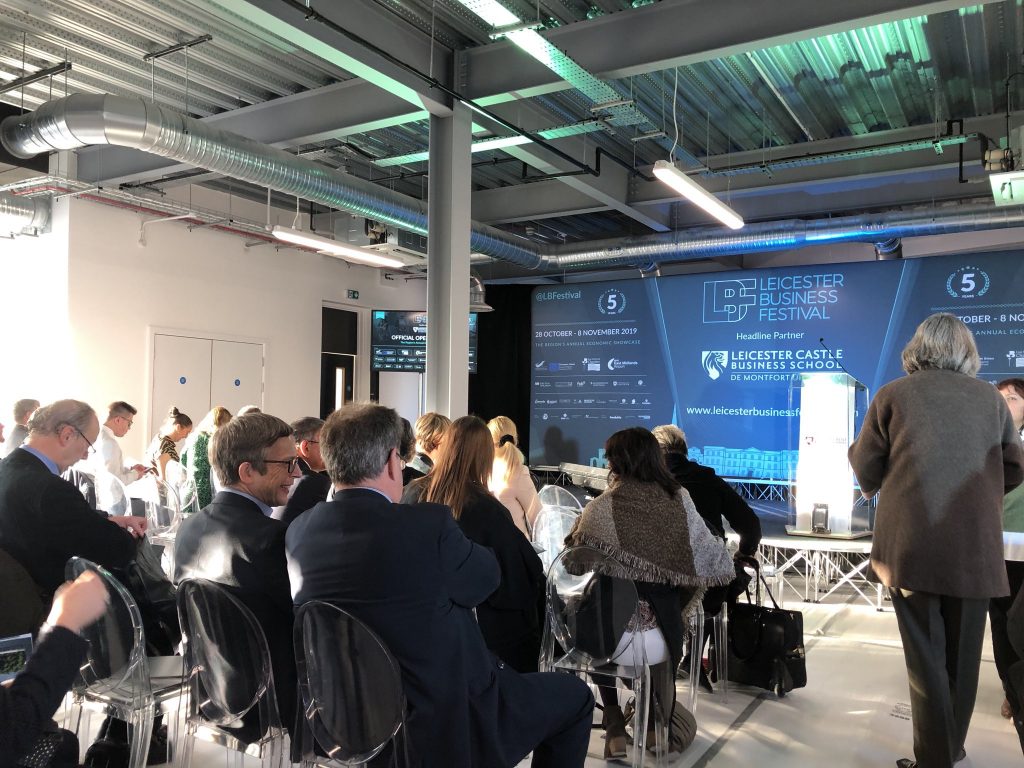 People sitting in rows of chairs waiting for a presentation at Leicester Business Festival 2019.