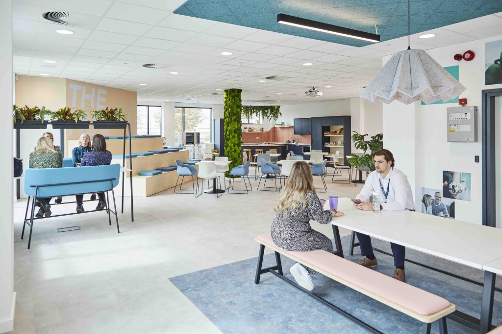Melton Building society HQ communal space with employees sitting at tables.